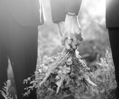 Couple holdiing hands over bouquet