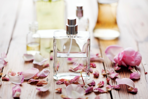 Perfume bottle on a table surrounded by flowers