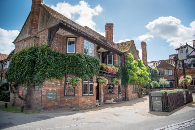 The Montagu Arms Hotel, red brick building close to road covered in ivy