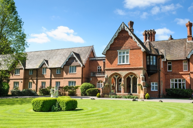 Audleys Wood Hotel, red brick building on manicured lawn blue skies