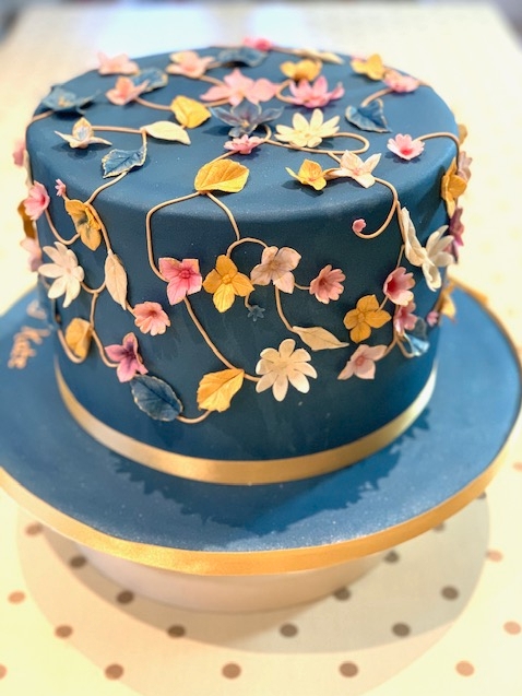 navy blue one tier cake with pink and yellow flowers