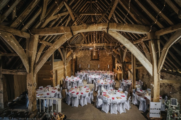 inside of barn set up for a wedding receptions with tables and chairs