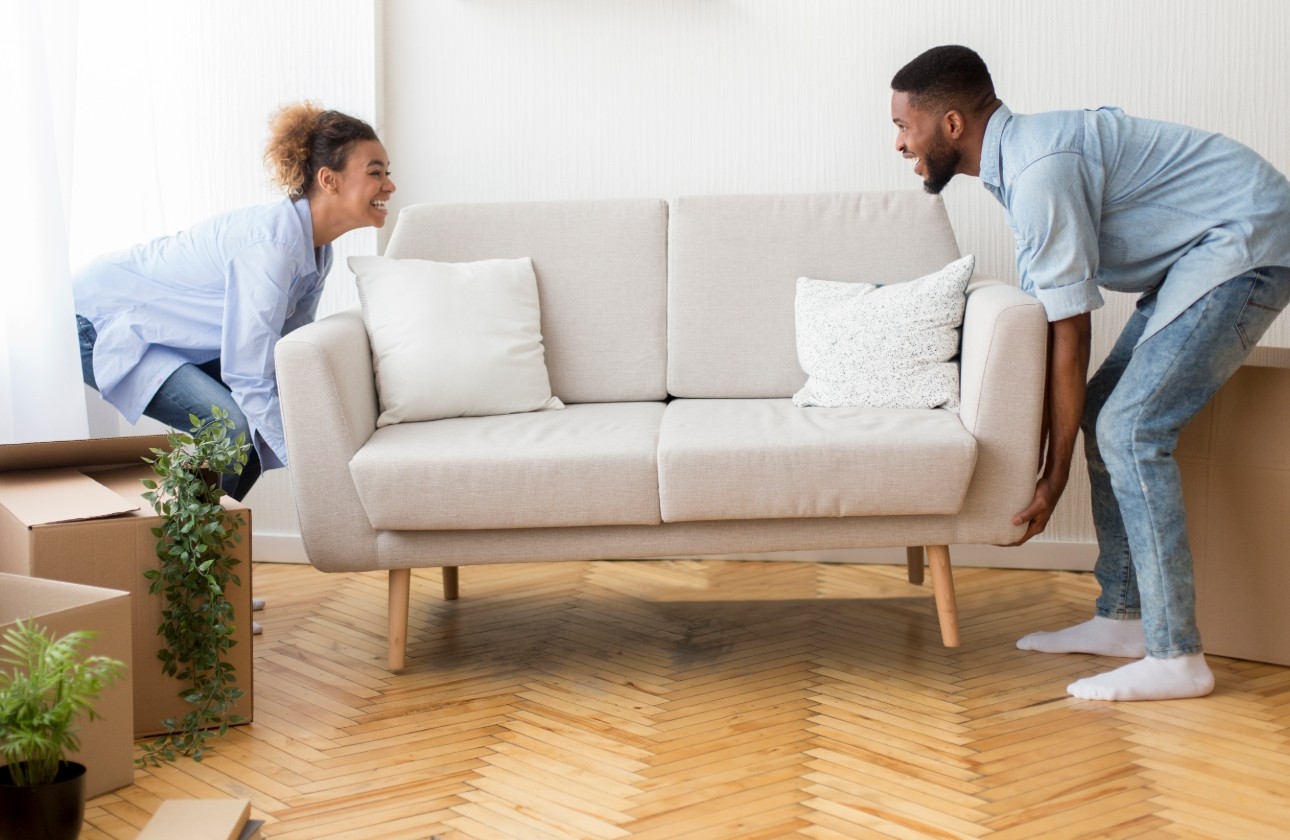 couple moving sofa together 