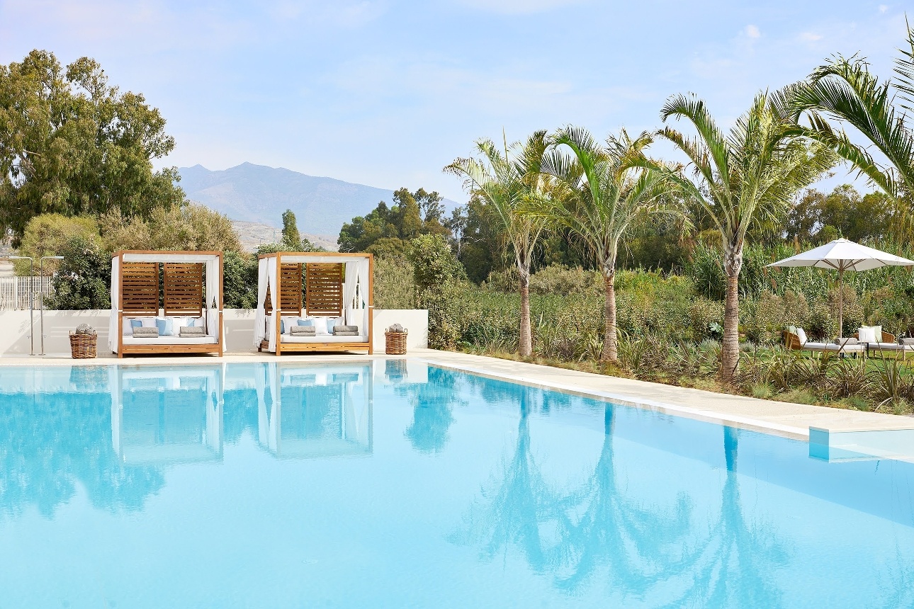 sun beds next to pool fourposter with canopy 