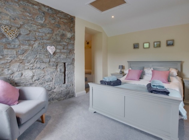 kingsized grey wooden bed armchair in room