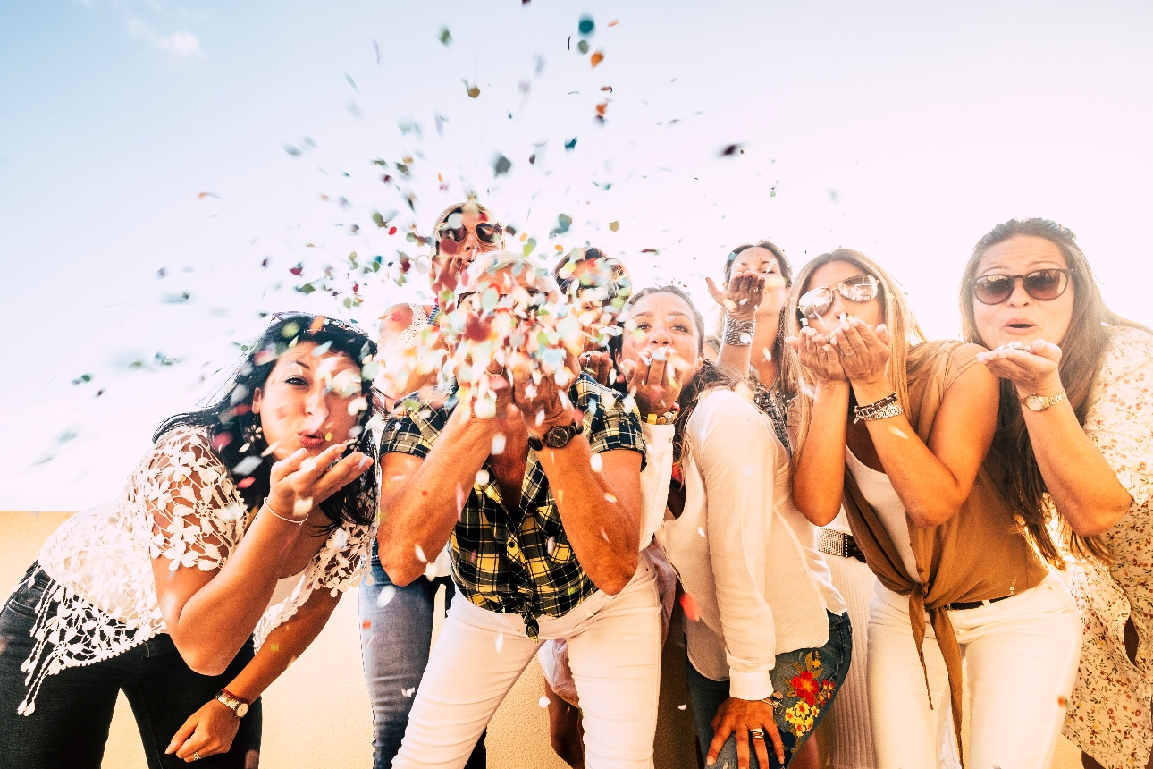 girls together blowing confetti