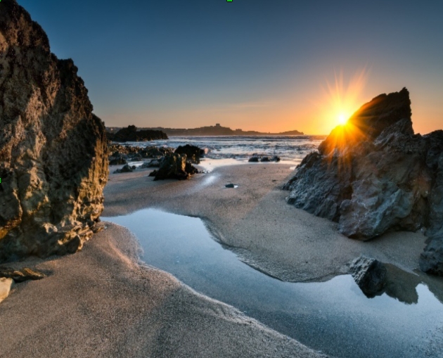 rocks on beach at dusk with sea