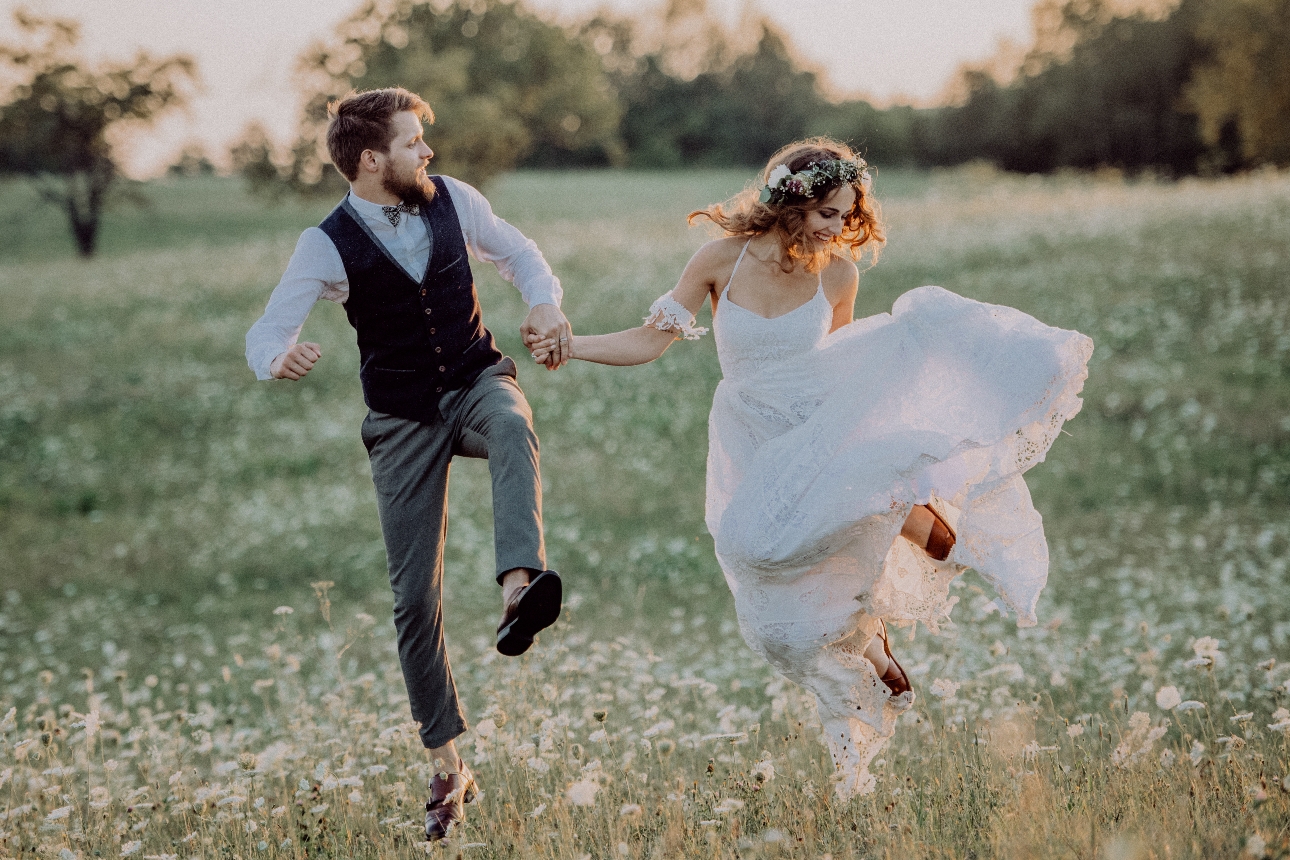 couple in wedding gear jumping in the air