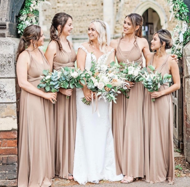 bride and bridesmaids in lovely dresses outside church