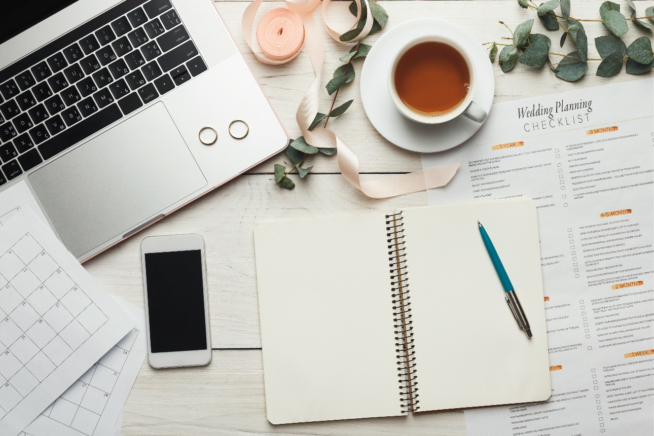 notepad, iphone, laptop, diary, coffee cup on a desk 