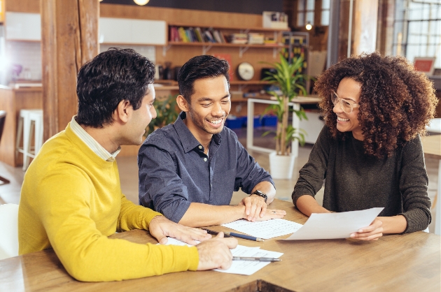 two men meeting a business woman at a coffee table