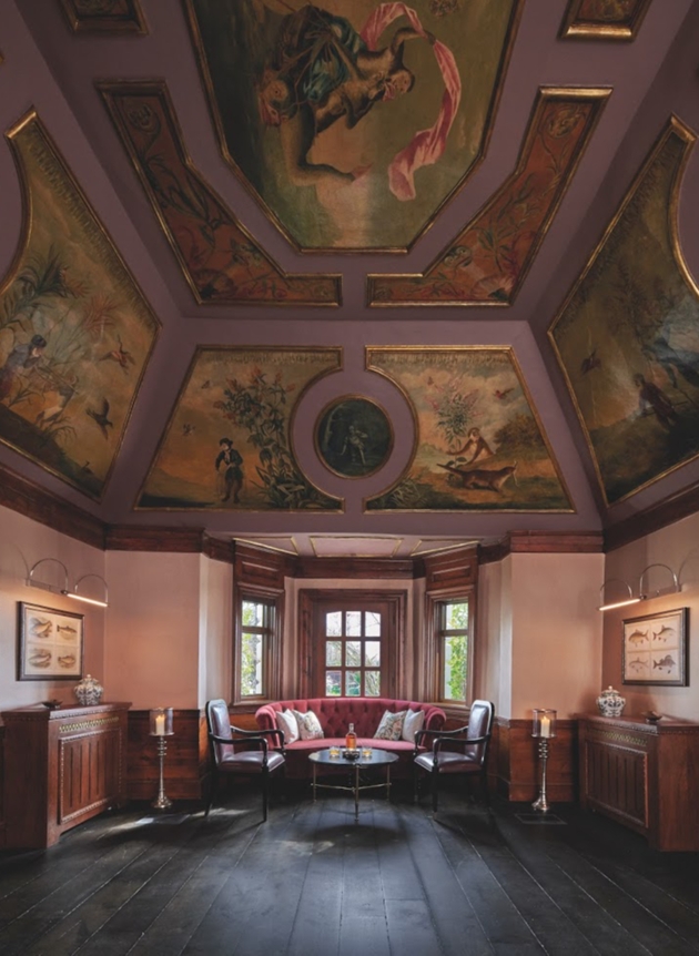 historic seating room with painted ceiling and red ornate chairs