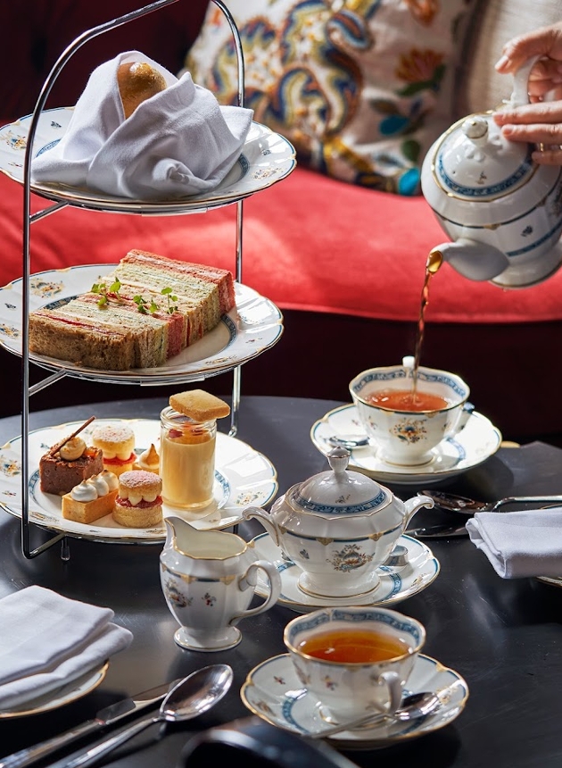 afternoon tea on a table plates with cakes and a pot of tea