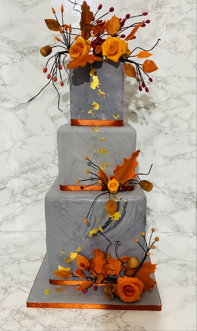 grey cake with orange leaves and details