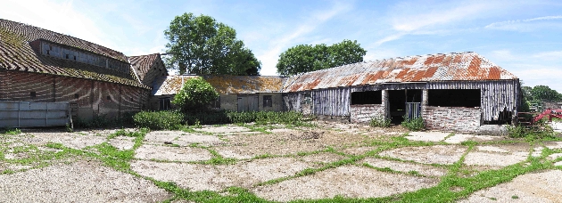 courtyard just rubble grass growing on paths broken barns