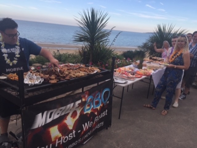 chef at barbecue grill with sea in background 