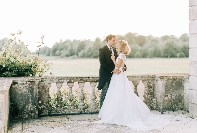 bride and groom standing on a terraced of a stately home