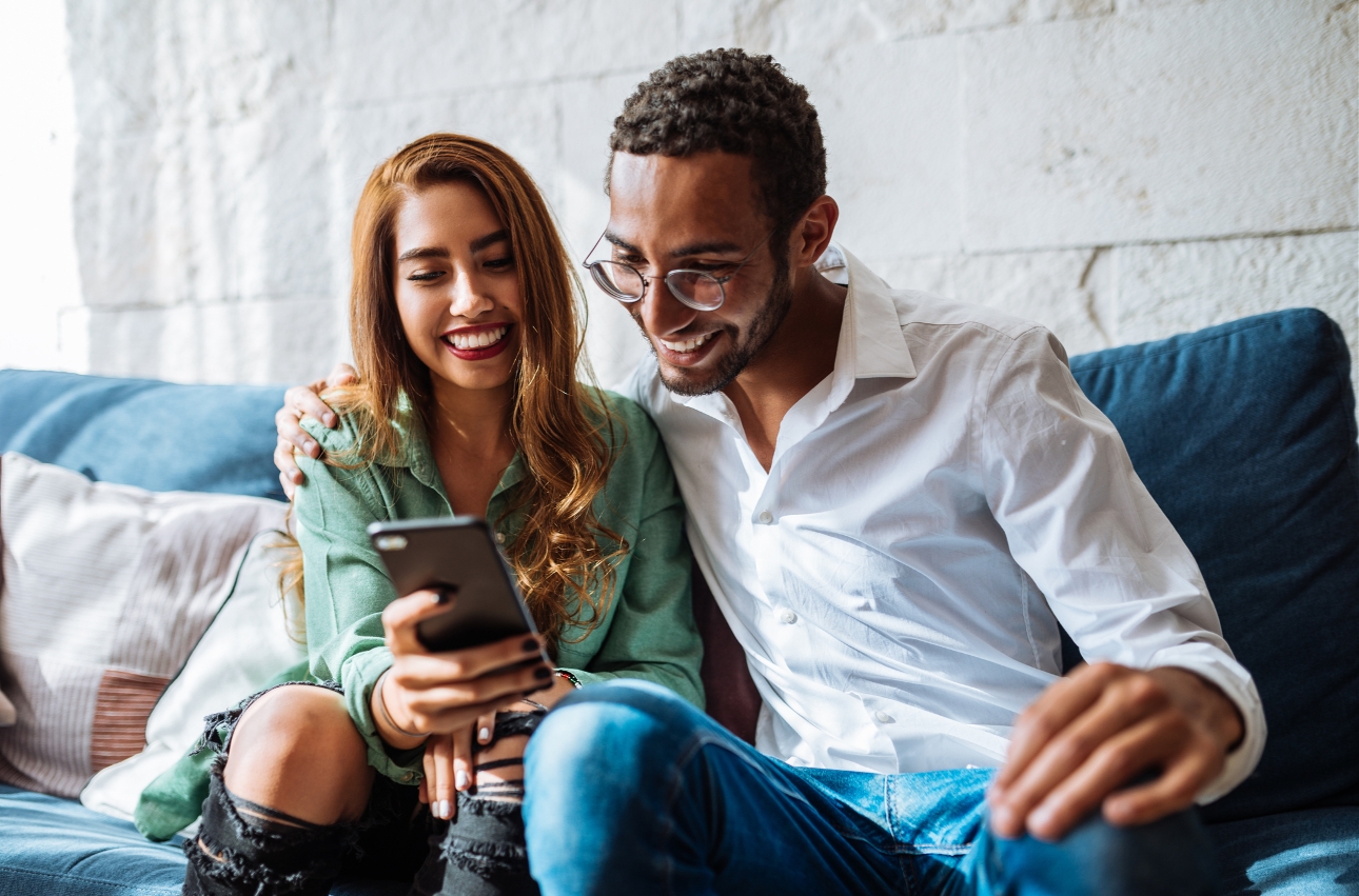 couple on sofa looking at a mobile phone