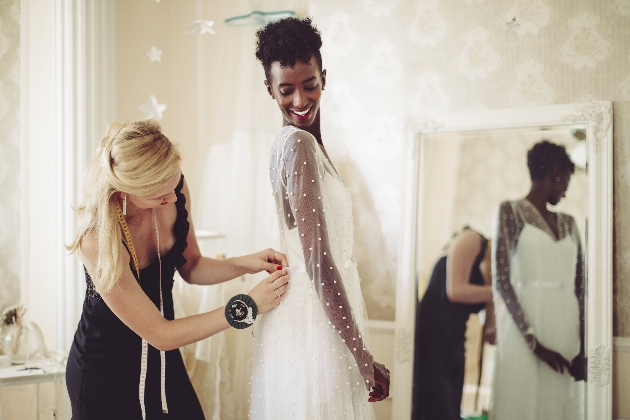 bride trying on wedding dress