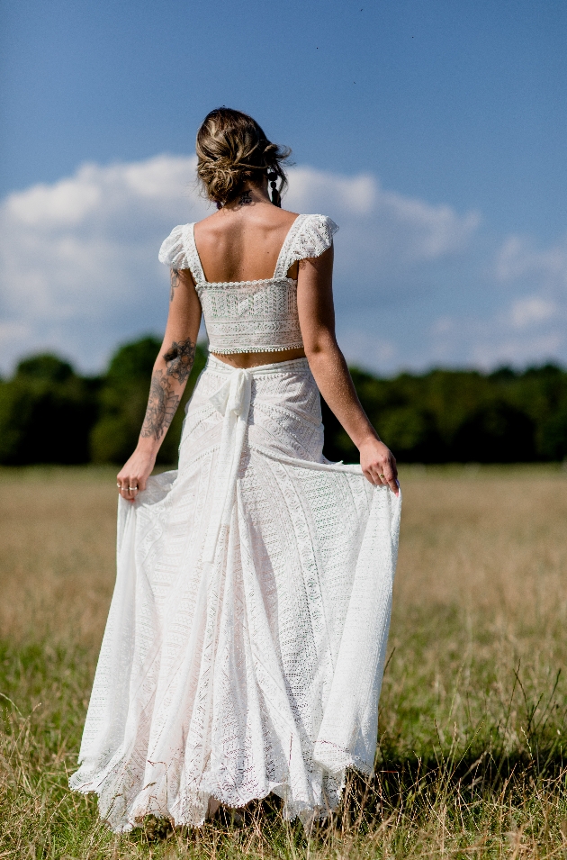 back shot of model in two piece wedding combo in a boho style with lace 