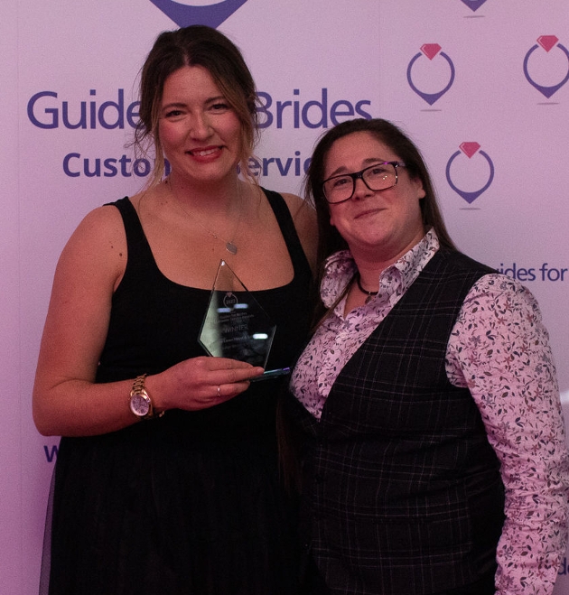 two people standing together holding award