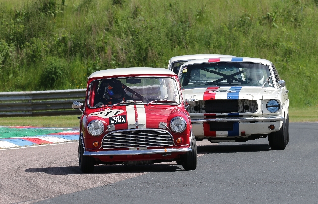 red retro mini and cream retro car racing on a track