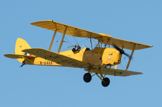 yellow vintage plane flying in the sky 