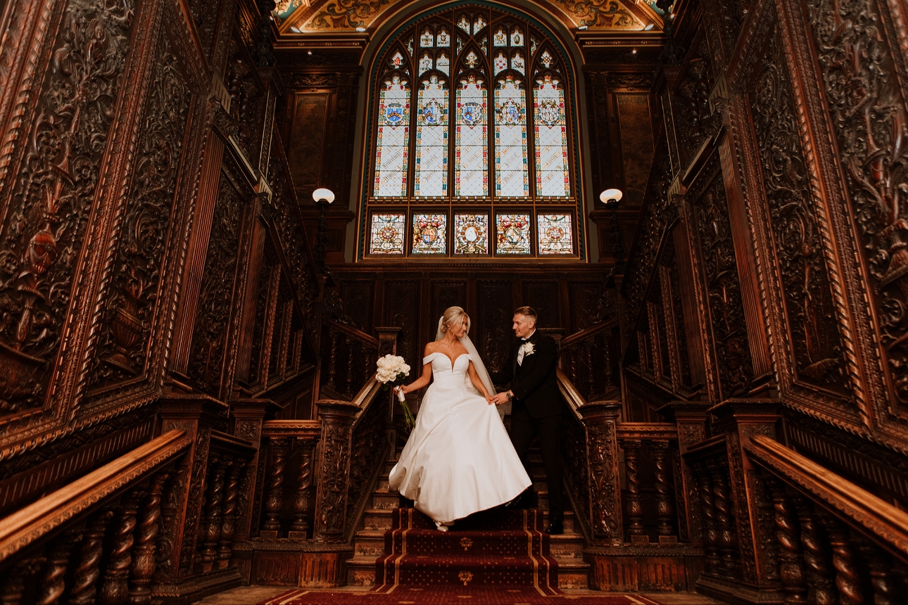 Couple walk down grand staircase
