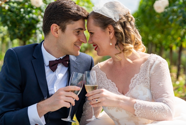 bride and groom sat down drinking champagne touching their foreheads