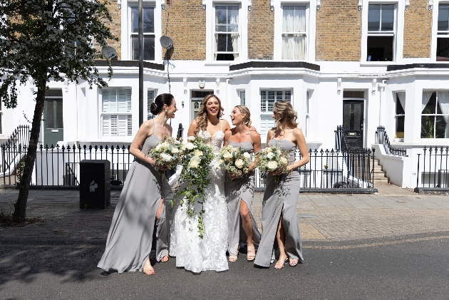 bride and bridesmaids posing in a road holding bouquets
