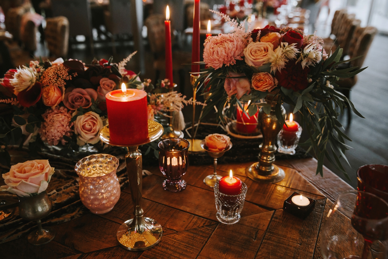 Winter wedding table with lots of red candles and foliage