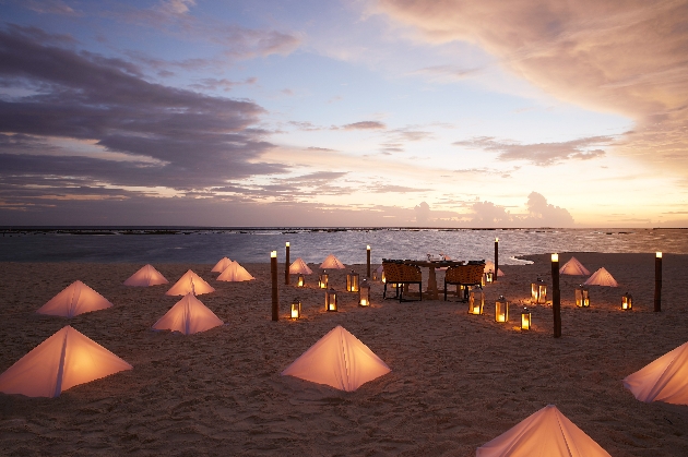 Romantic dinner on the beach surrounded by lights