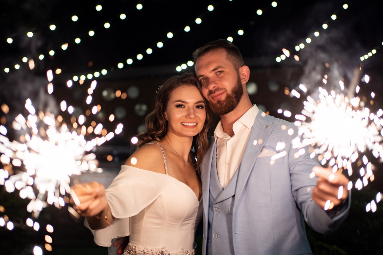 bride and groom waving sparklers