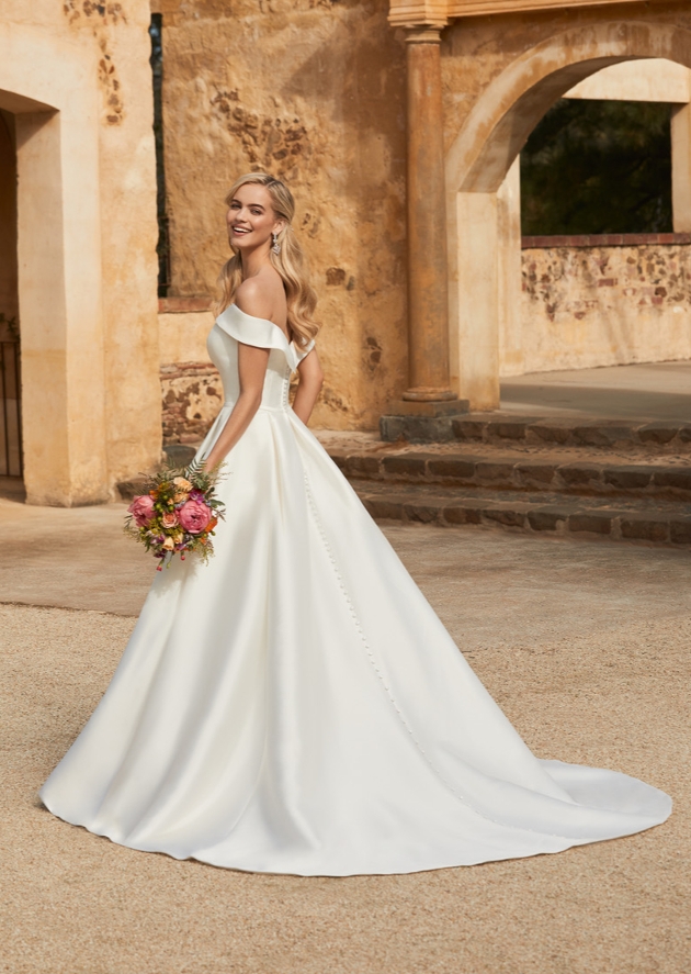 model in duchess satin off-shoulder bardot-style gown