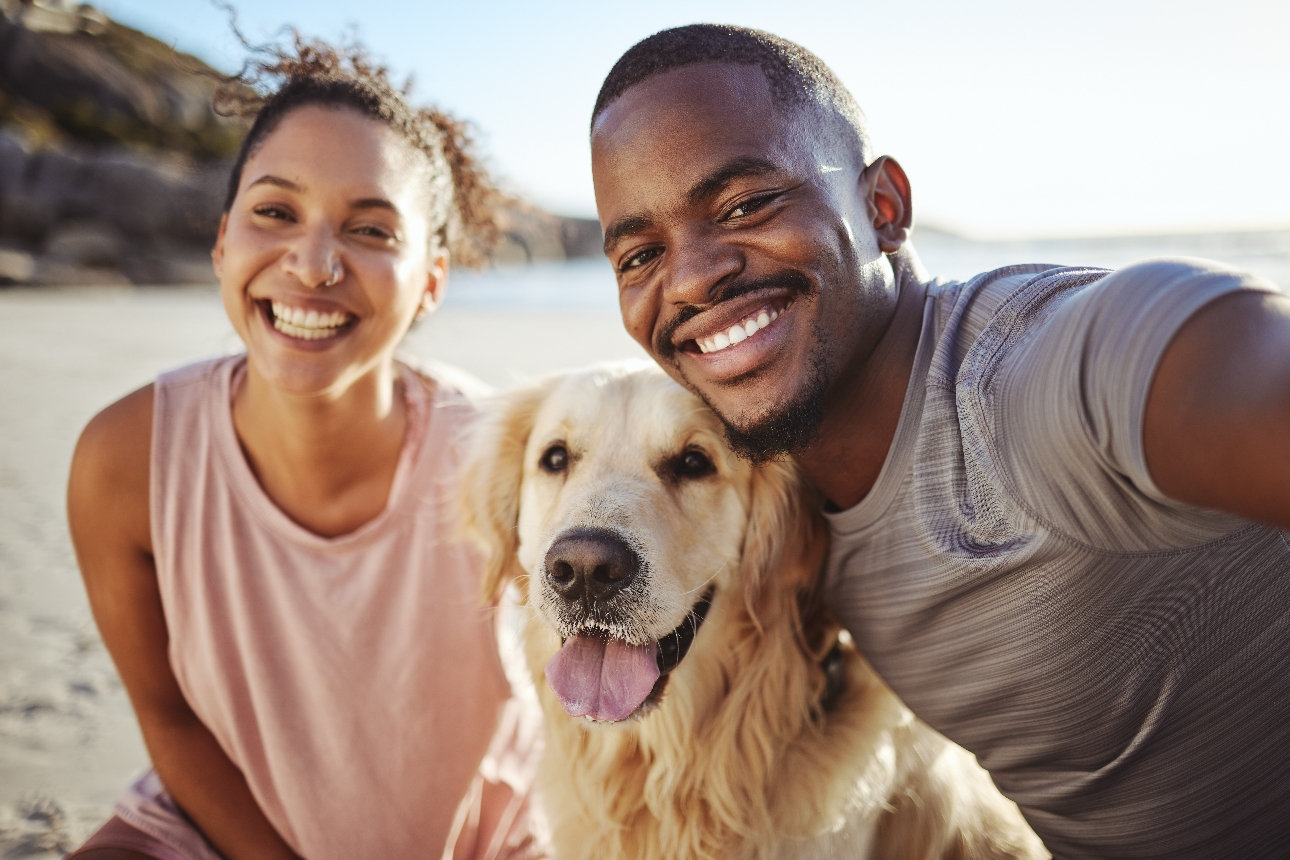 couple on beach with their pet dog