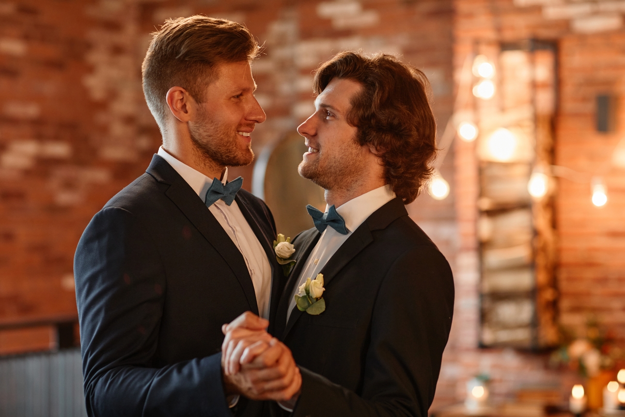 two grooms in suits dancing