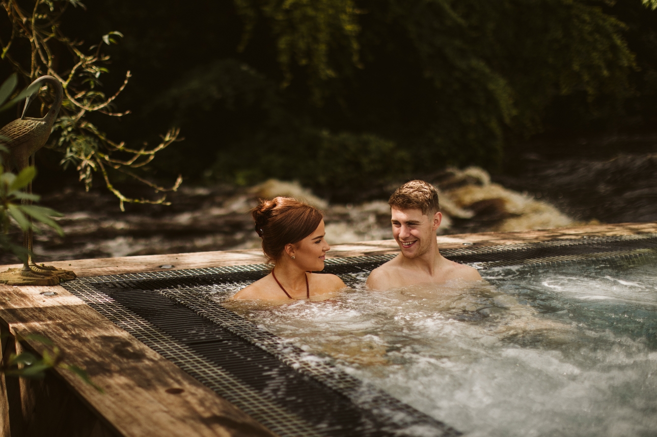 couple sat in a hot tub outside
