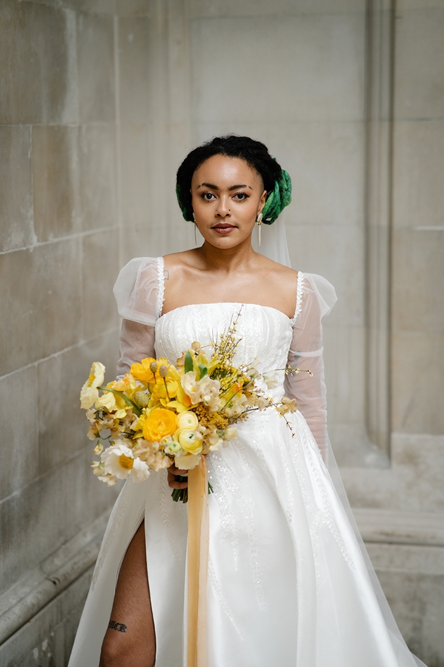 model in bride dress holding bouquet