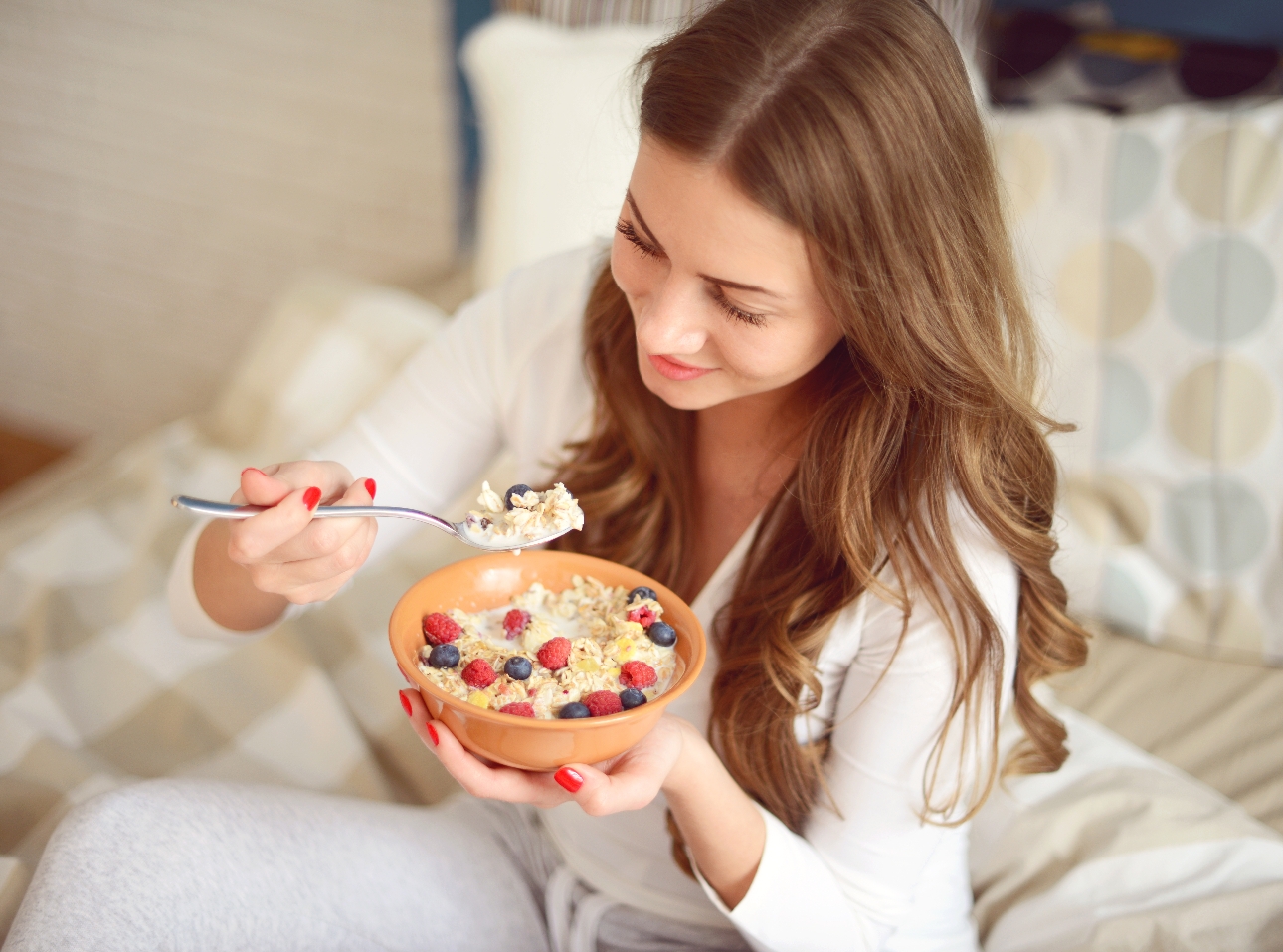 woman eating bowl of oats and fruit