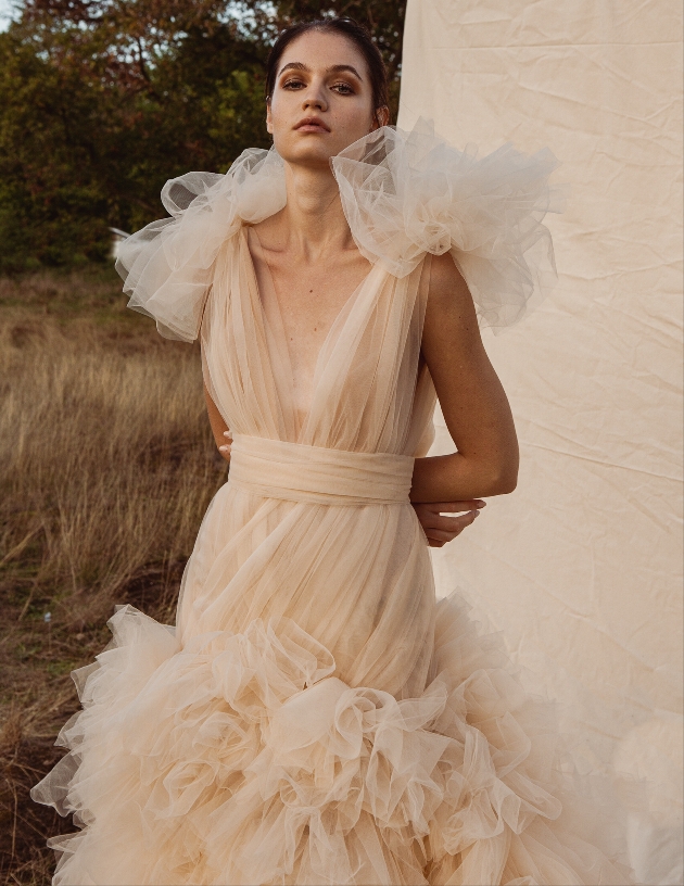 model in fishtail dress with layered fabric and layered arms 