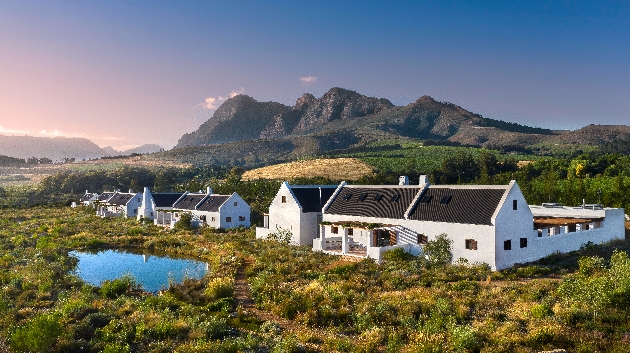 Several white buildings surrounded by mountains and greenery