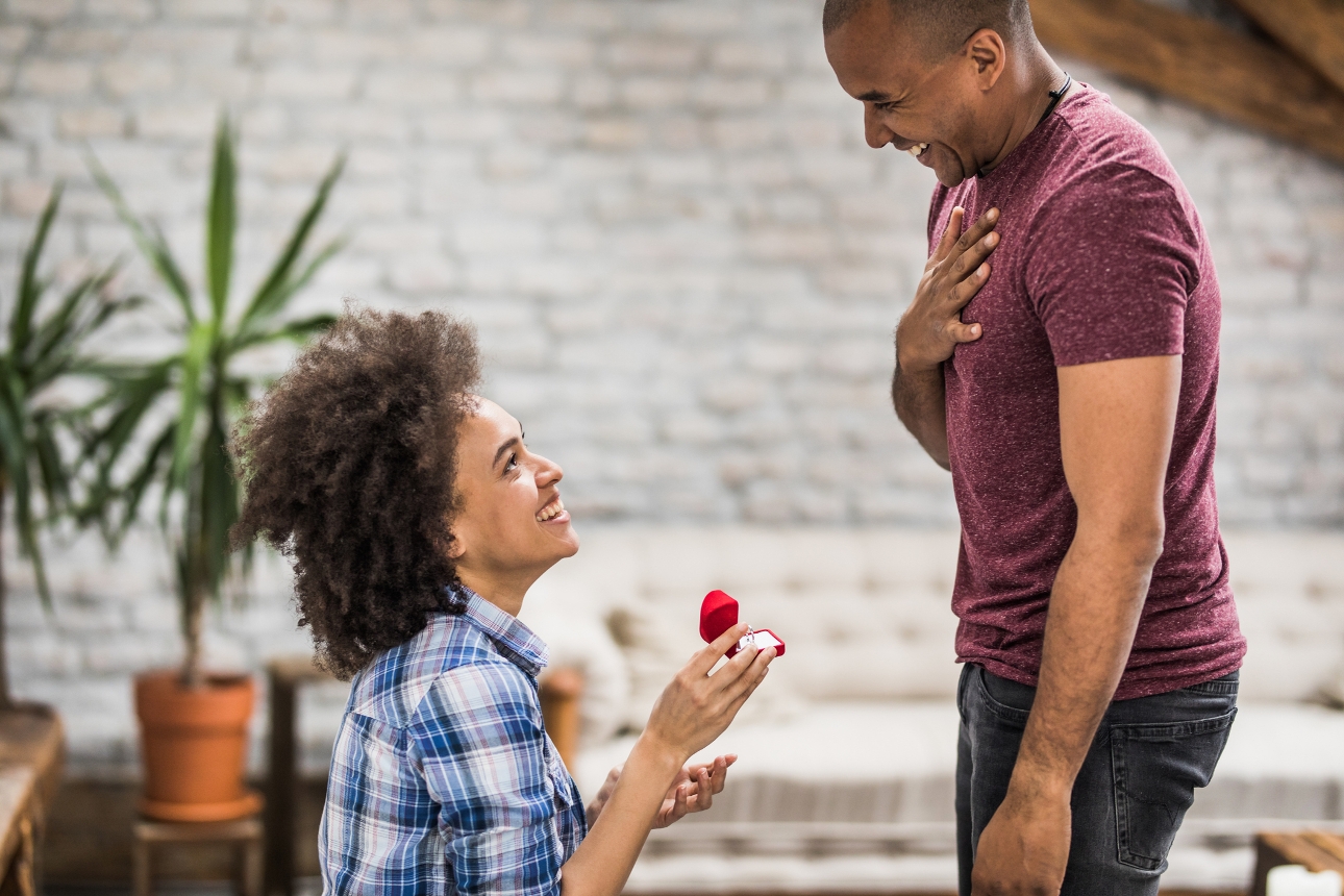 woman down on one knee proposing to a man