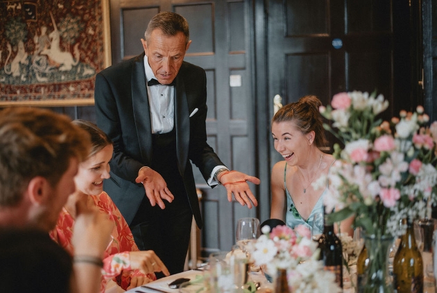 magician in suit performing a trick at a table