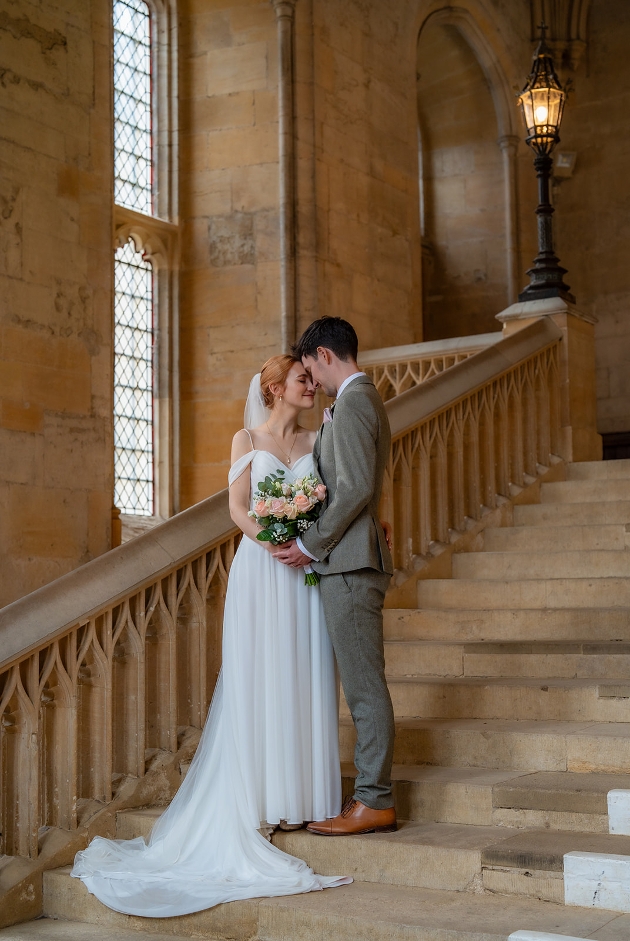 bride and groom on his big day on stone steps