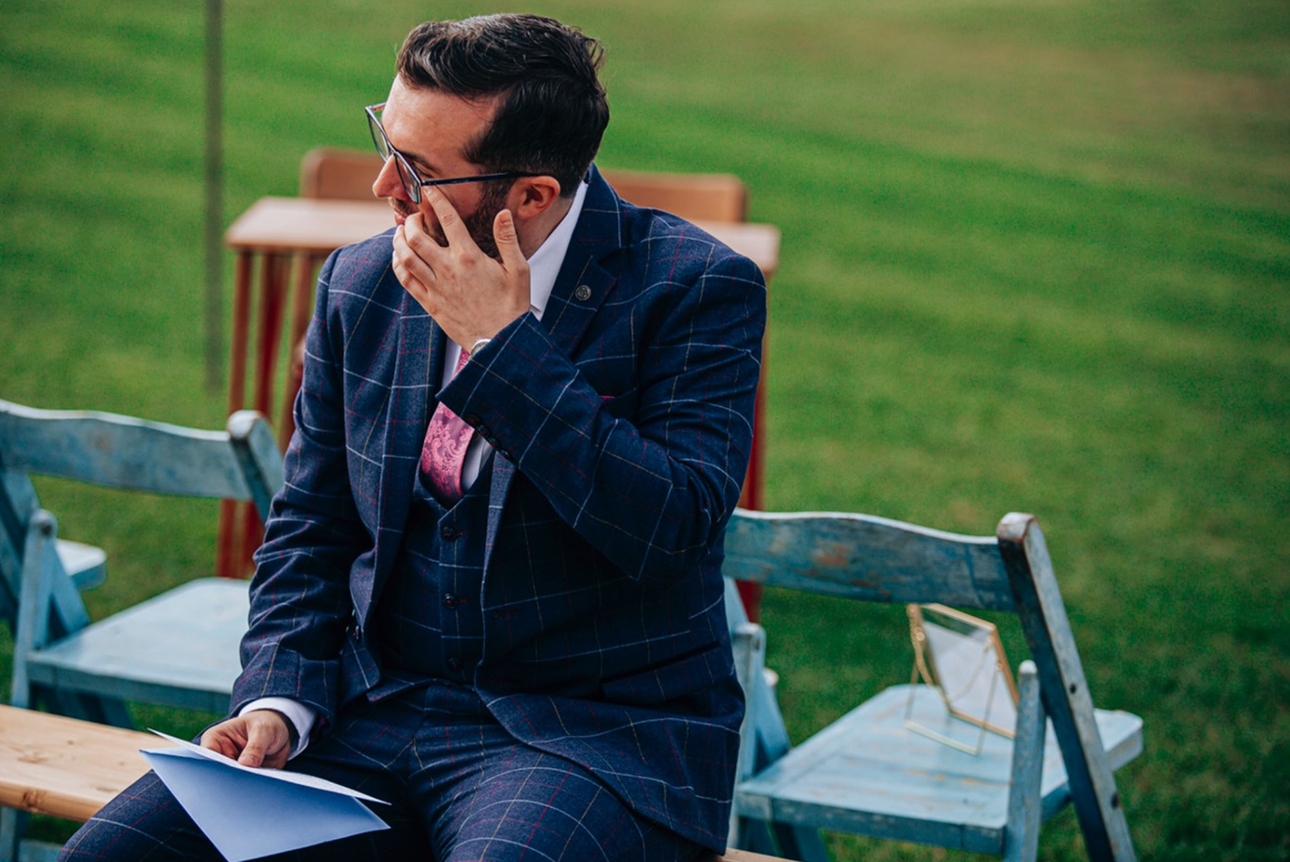 groom reading speech with tear in his eye