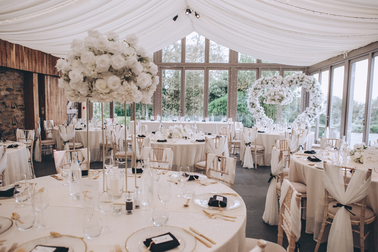 set out reception room with big heart back drop and floral centrepieces on tables