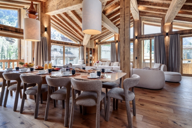 inside shot of chalet with large dining table and long sofa 