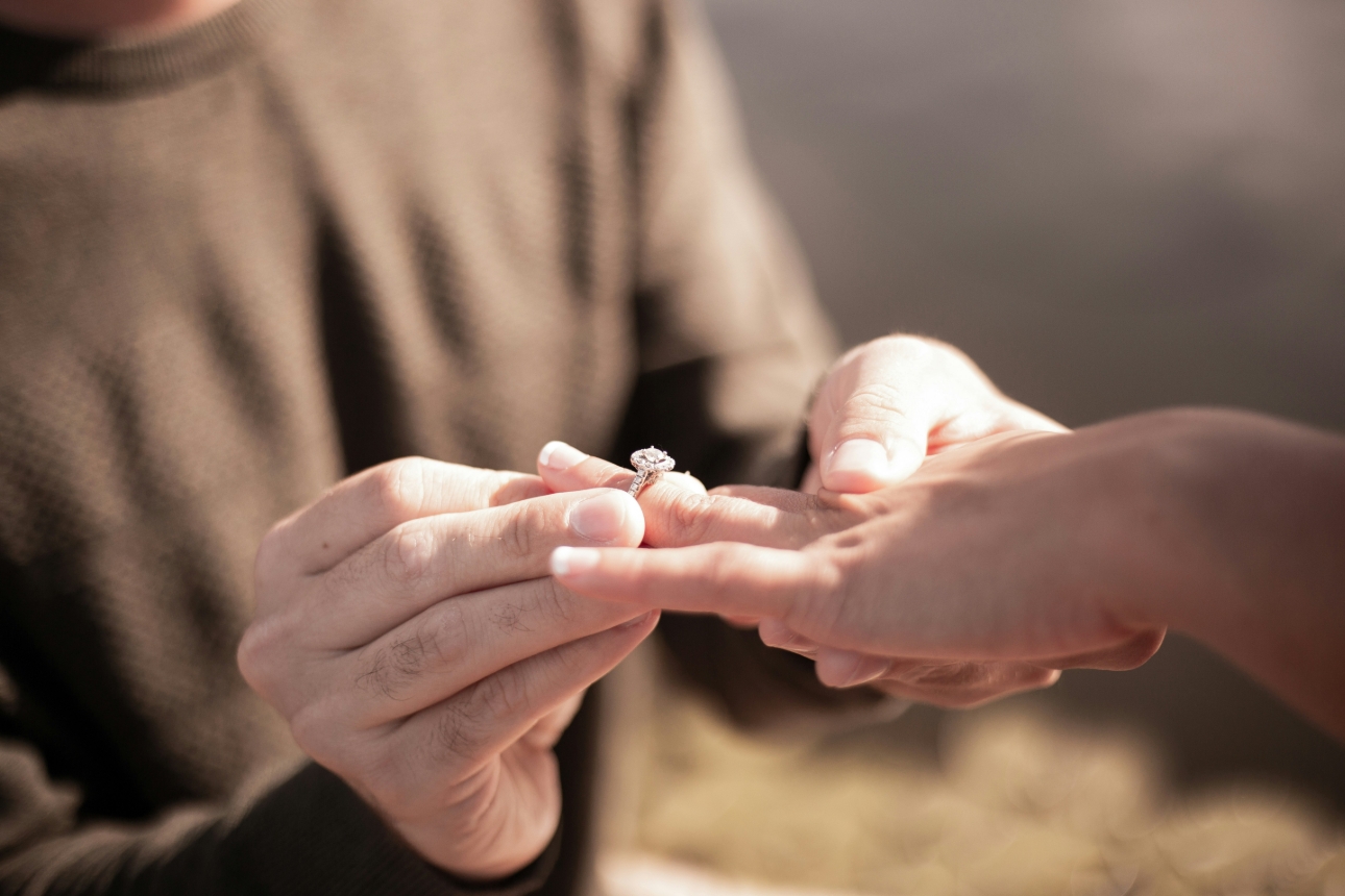 man popping engagement ring on a woman's finger