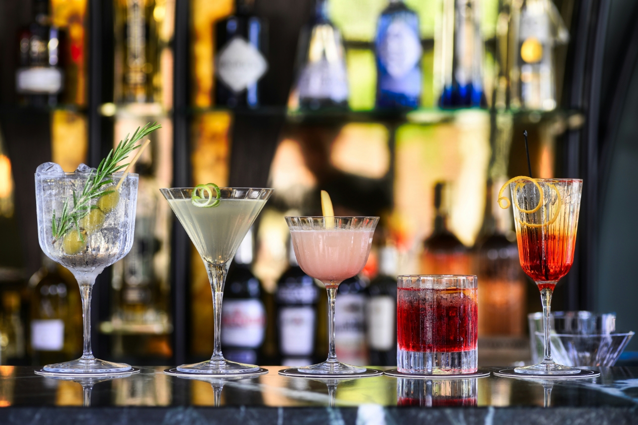 row of different cocktails on a bar
