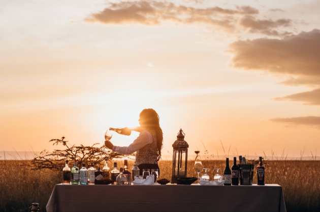 lady serving drinks outside at sunset